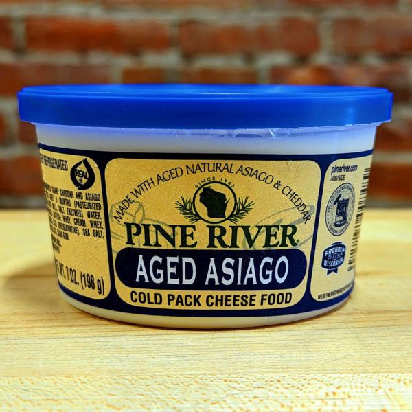 A tub of Aged Asiago cheese spread.