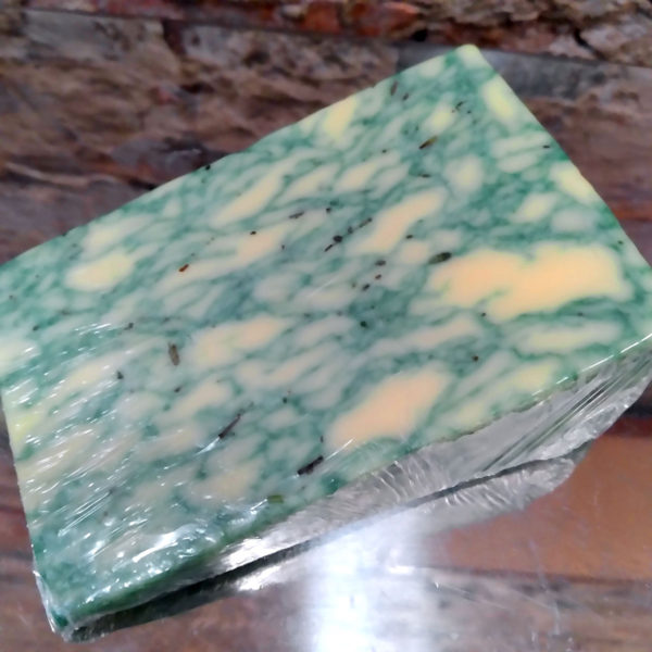 A closeup view of a wedge of Sage Derby cheese.