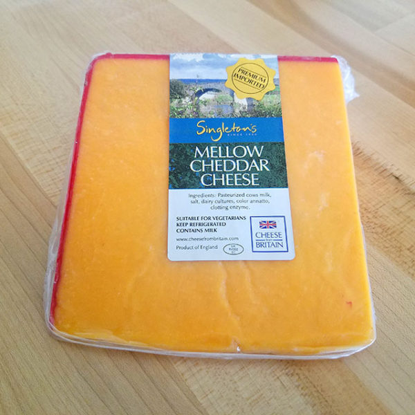 A wedge of Singleton's Mellow Cheddar cheese.