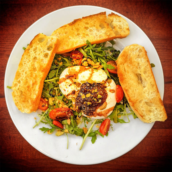 Burrata salad with arugula, fig jam, and pistachios