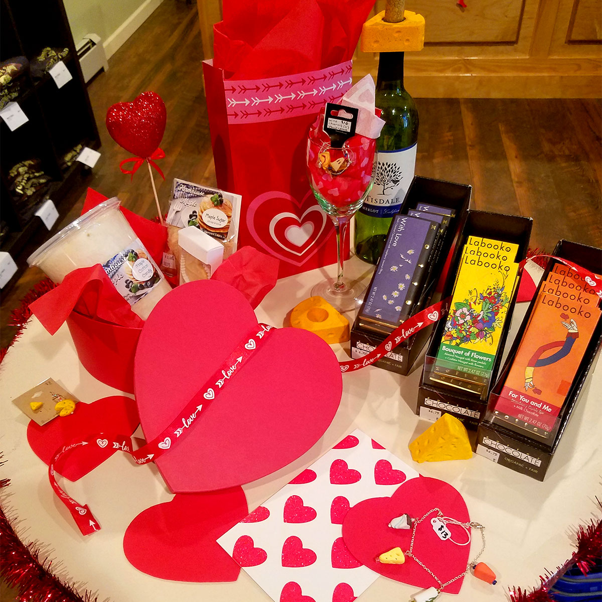 A table covered with Valentine's Day decor and gifts from the cheese shop.
