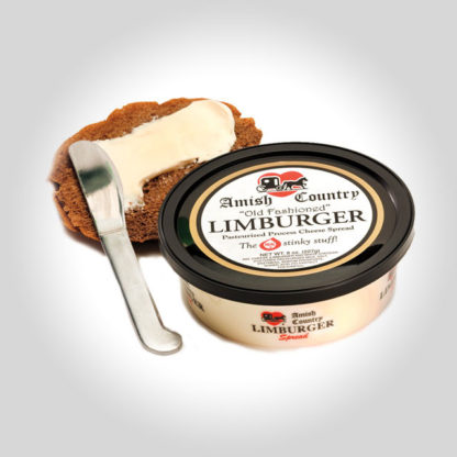 A tub of Amish Country Limburger Spread and a piece of bread being slathered in cheese.