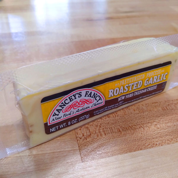 A block of Yancey's Fancy Roasted Garlic Aged Cheddar cheese.