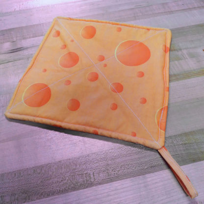 A pot holder with a swiss cheese pattern.
