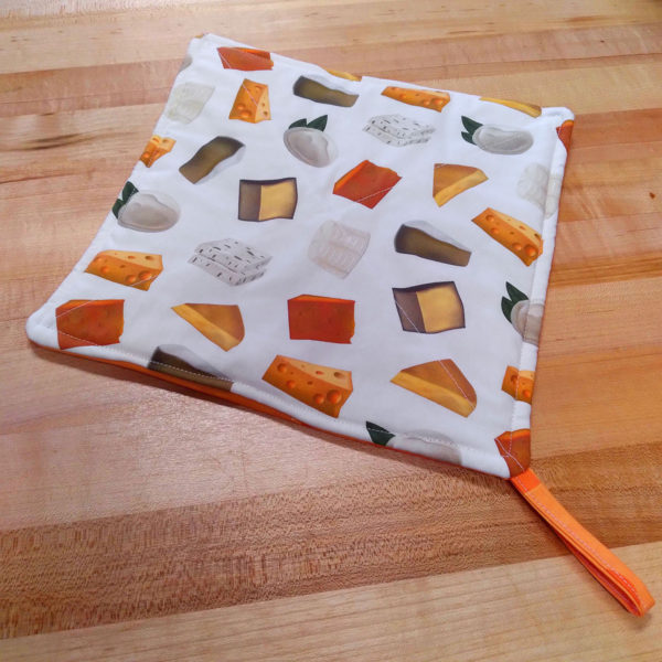 A pot holder with a cheese wedge pattern.