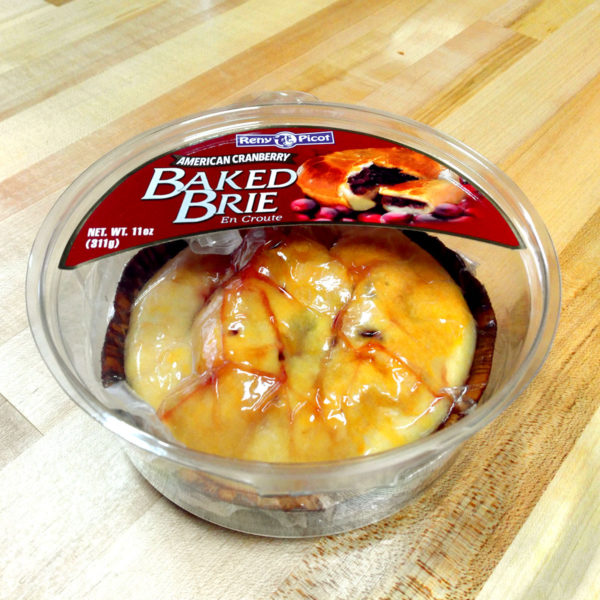 Lower angle depicting Reny Picot baked Brie in a plastic container.