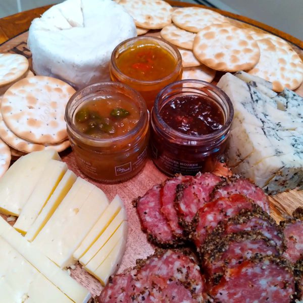 An assortment of Just For Cheese accompaniments on a cheese platter.