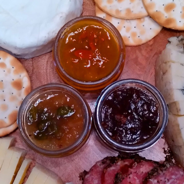 A closeup view of an assortment of Just For Cheese accompaniments.