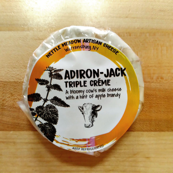A wheel of Adiron-Jack cheese, in wrapper.