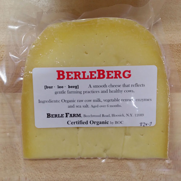 A wedge of BerleBerg cheese with label.