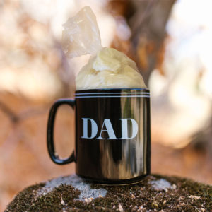 A bag of cheese curd sticking out of a "DAD" mug.