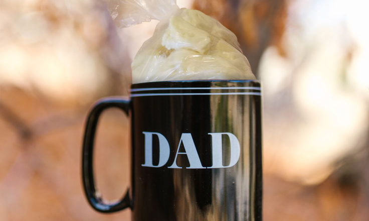 A bag of cheese curd sticking out of a "DAD" mug.