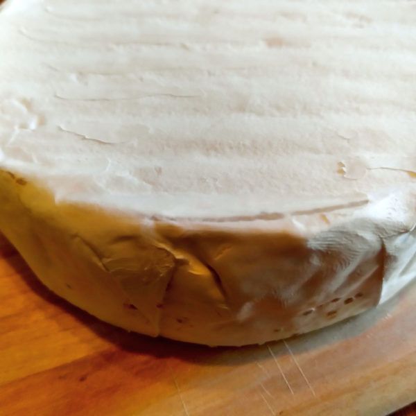 Closeup of a wheel of Triple Creme Goat Brie.