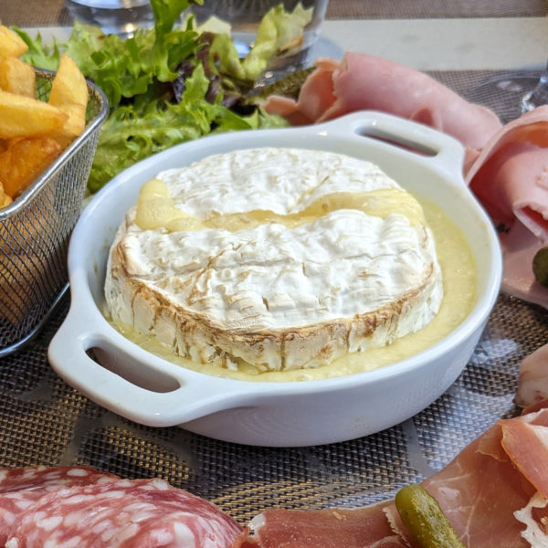 Warm camembert with cold meats, fries, and salad.