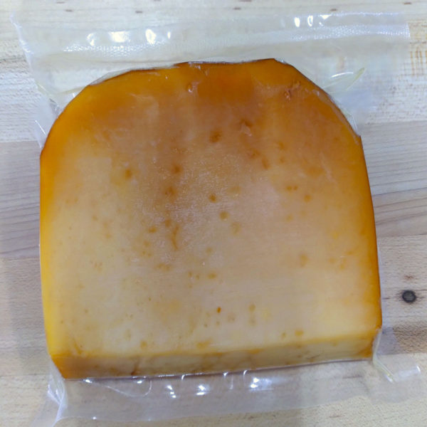 Back of a wedge of Smoked Raw Milk Gouda.