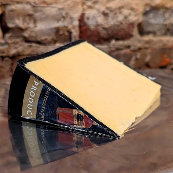 An alternate view of a wedge of Kerrygold Aged Cheddar with Irish Whiskey.