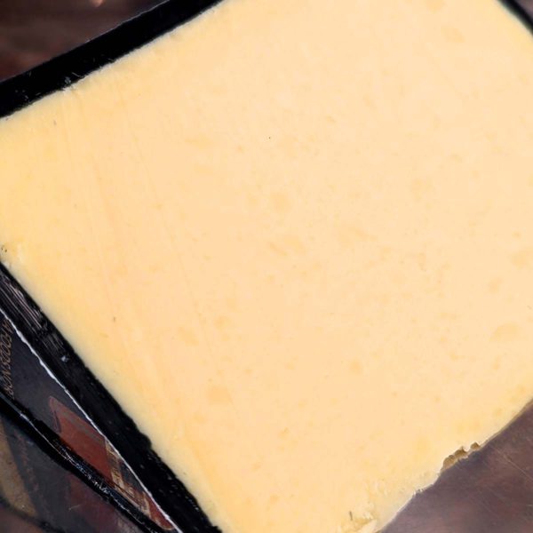 A closeup of a wedge of Kerrygold Aged Cheddar with Irish Whiskey.