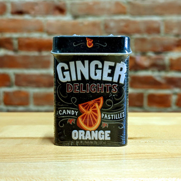 The front of a tin of Orange Ginger Delights candy.