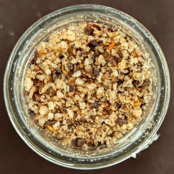 A closeup view of the contents of a jar of Chili Black Lime Syracuse Salt.