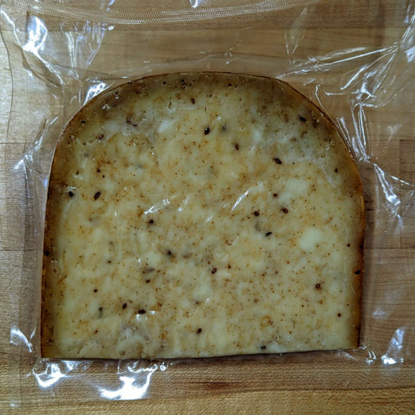 Reverse side of a wedge of Jake's Gouda Nokkelost cheese.