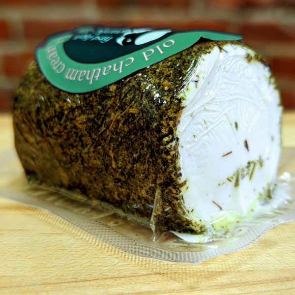 Side view of a log of Fresh Garlic & Herb Goat Cheese, wrapped.