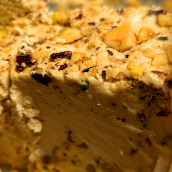 A closeup of Lebanon Valley Halawa, unpackaged and sliced, revealing the smooth center and pistachio-encrusted top.