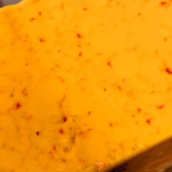 A closeup of Carolina Reaper Cheddar cheese.