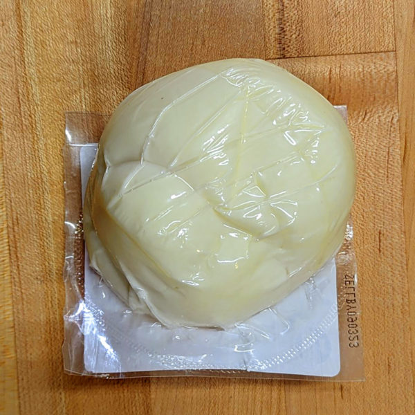 Back view of a ball of Oaxaca cheese in the packaging.