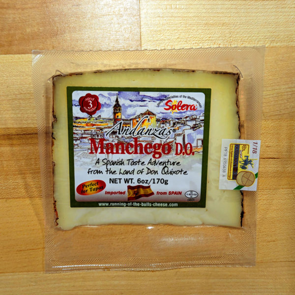 A packaged wedge of Andanzas Manchego cheese.