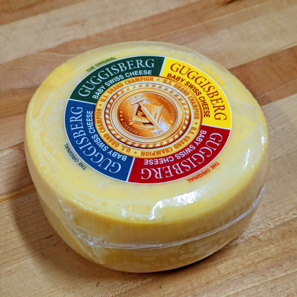 Side view of a 2 lb. wheel of Guggisberg Baby Swiss cheese.