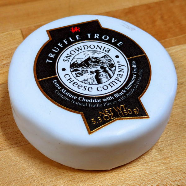 Closeup of a truckle of Truffle Trove cheese in white wax.