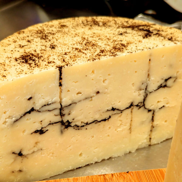 A cut wheel of The Truffle Kid, revealing the interior marbled with blacktruffle.