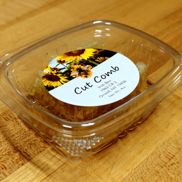 Close-up view of a container of cut honey comb.