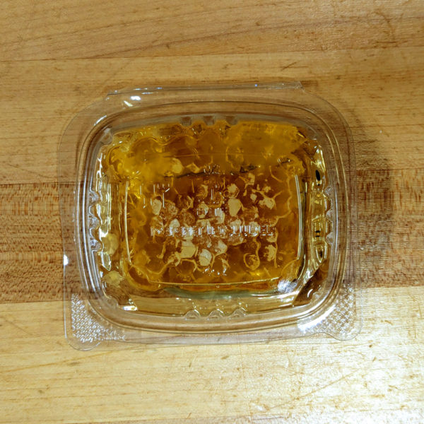 Bottom view of a container of cut honey comb.