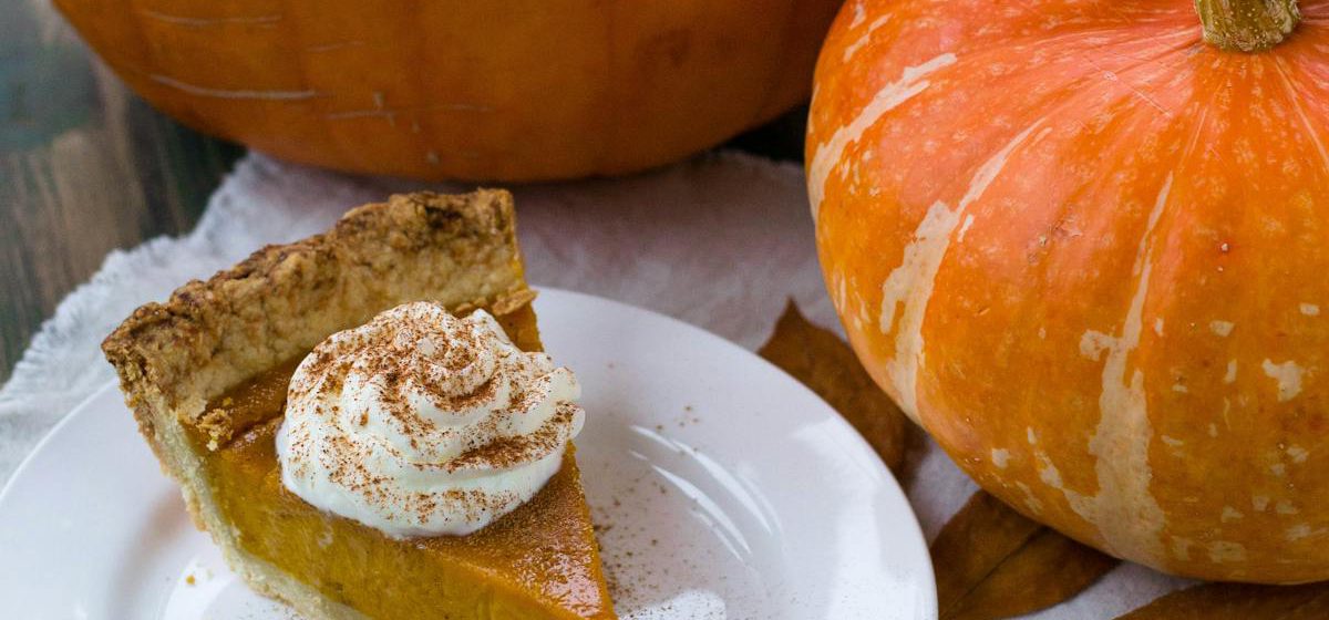 Delectable sliced pumpkin pie on a white ceramic plate.