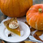 Delectable sliced pumpkin pie on a white ceramic plate.