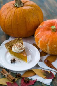 Delectable sliced pumpkin pie on a white ceramic plate.