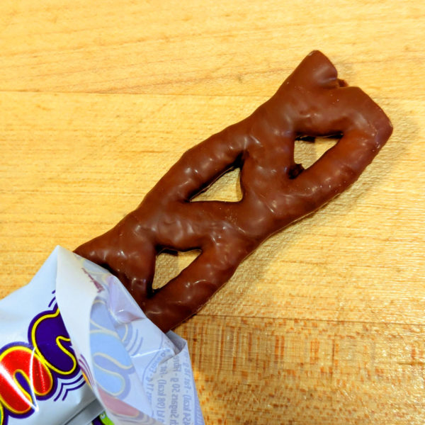 A partially unwrapped Curly Wurly, illustrating the chocolate-covered caramel lattice pattern.