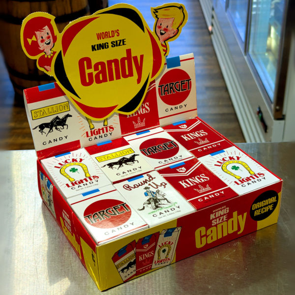 A container of assorted candy cigarette boxes.