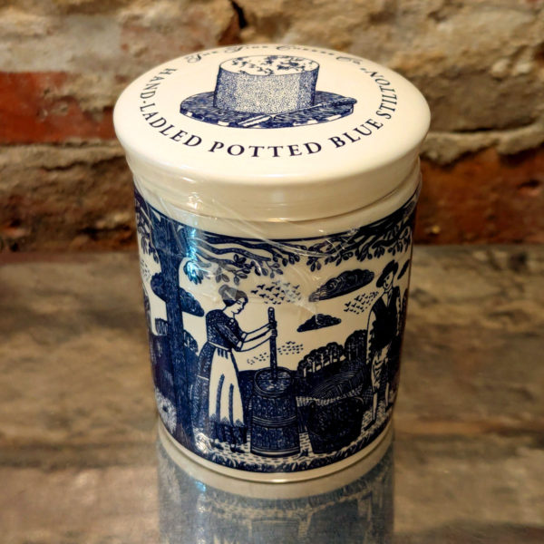 An unopened pot of Stilton, showing the blue illustrations on white ceramic.