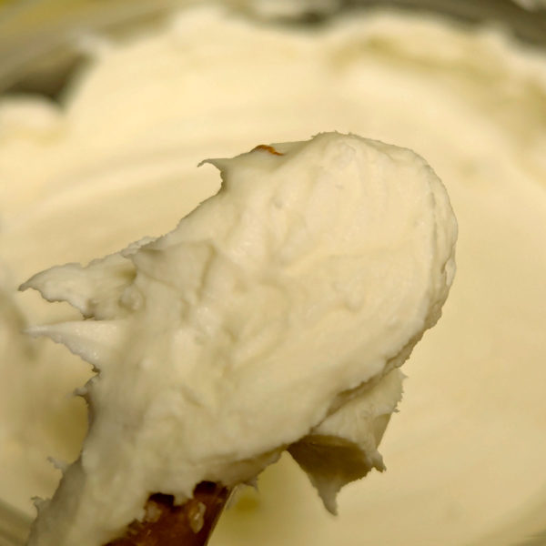 A closeup of New York Creme Cheese scooped out of the container and ready to spread.