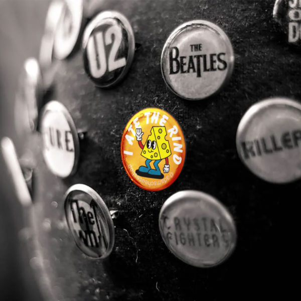 An "I Ate the Rind" button amongst other souvenir rock band buttons.