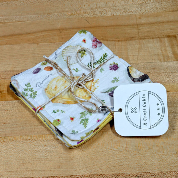 A stack of four cloth drink coasters made from fabric with a cheesy pattern, tied together with twine.
