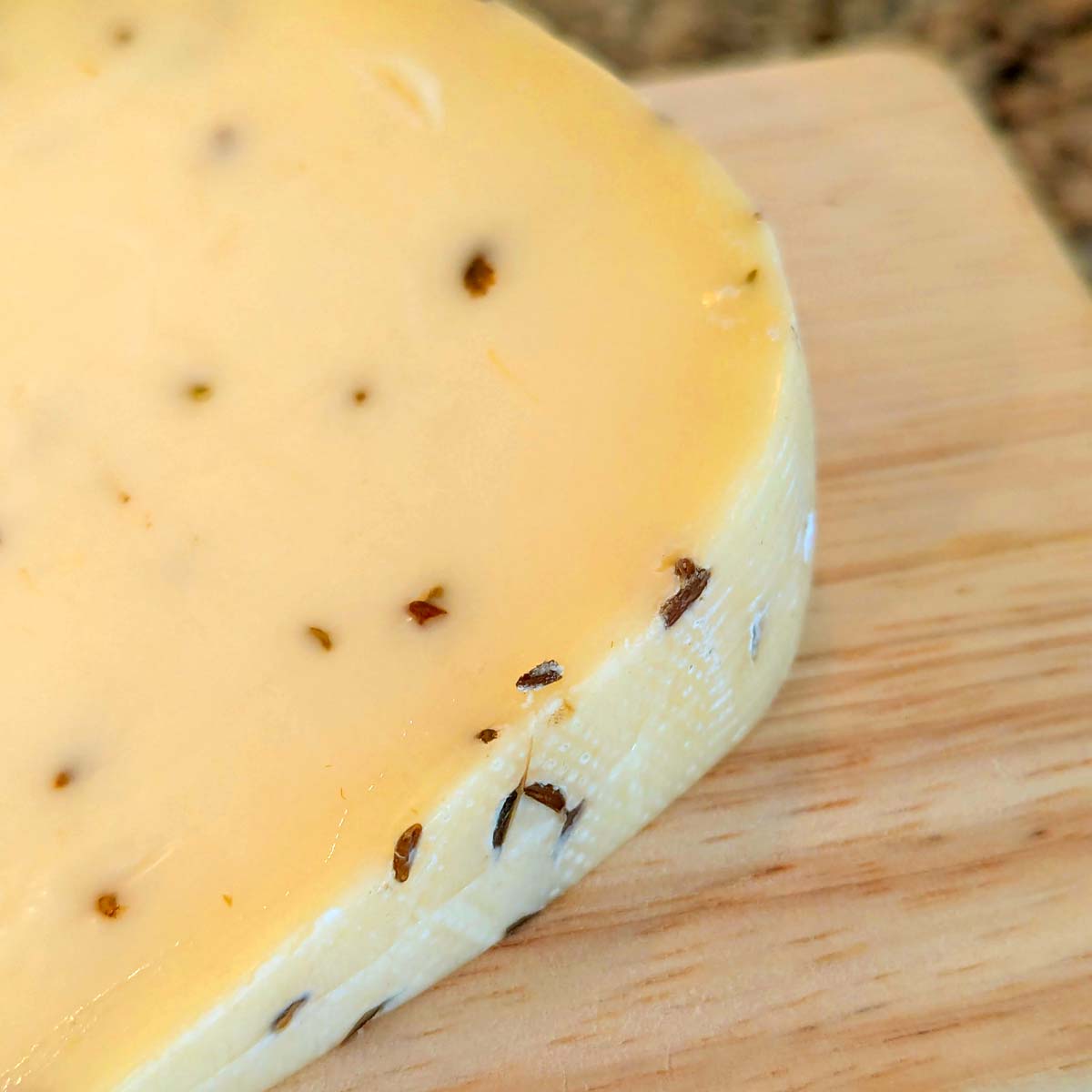 A closeup of Gitane on Weck's rind and paste, with prominent caraway seeds.