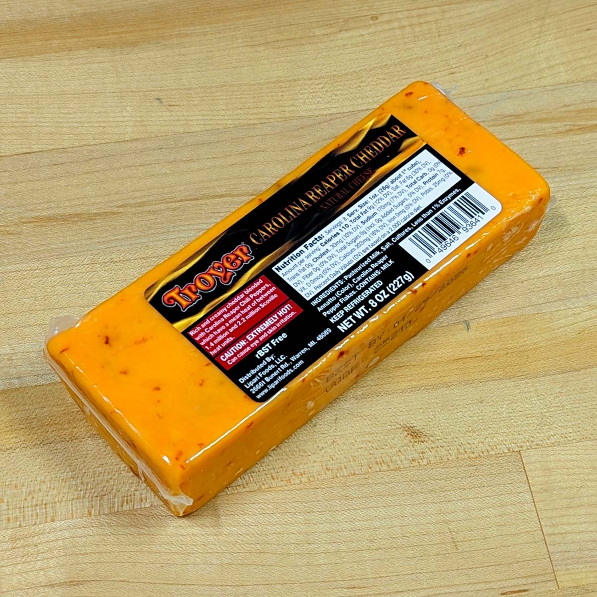 An alternate angle of a block of Carolina Reaper Cheddar, in its packaging.