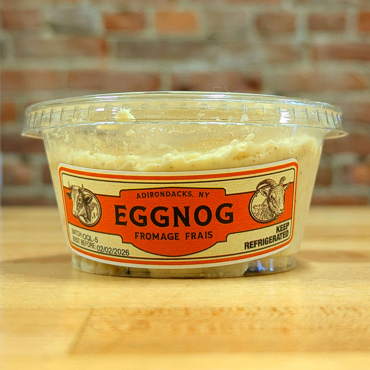 Front view of a container of Eggnog Frais cheese.