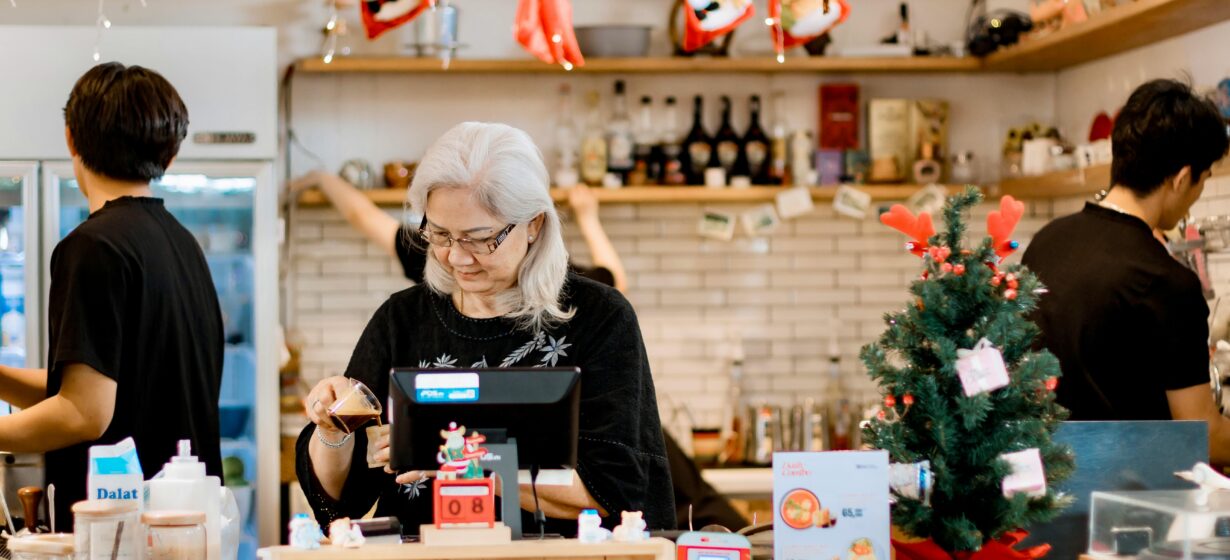 Festive Cafe Scene with Elderly Woman at Counter
