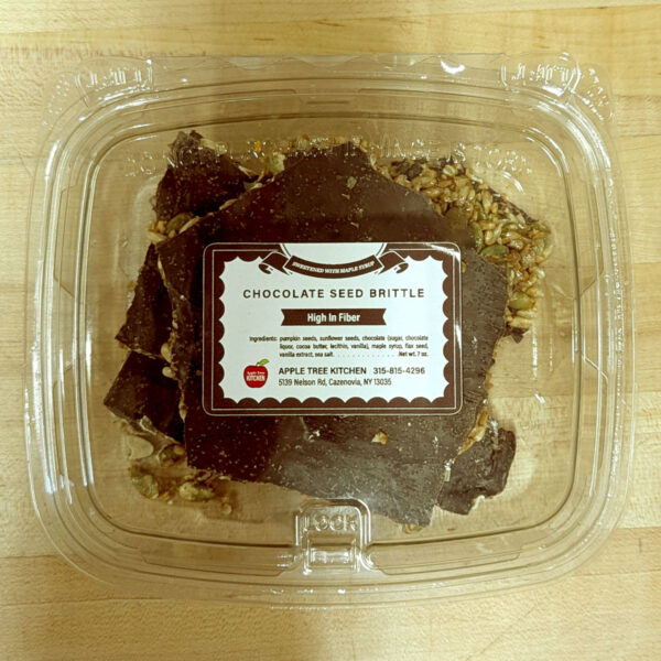 A closeup of a container of chocolate seed brittle.